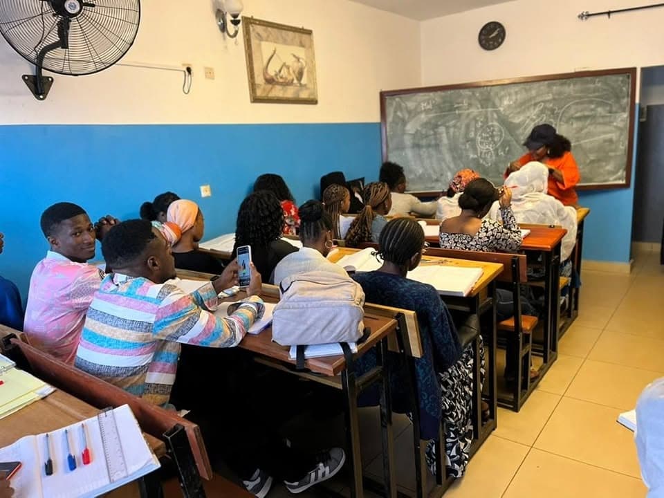 Enseignant animant un cours au tableau devant les étudiants